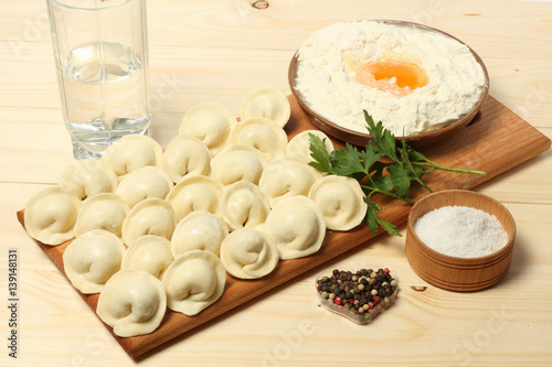 raw russian pelmeni on wood background