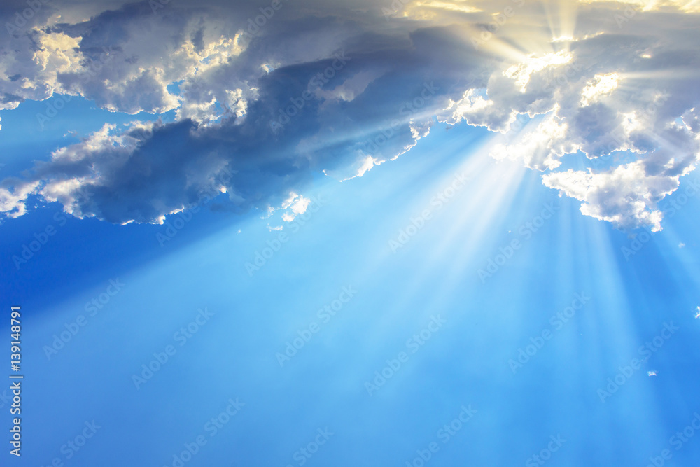 Sun light rays or beams bursting from the clouds on a blue sky. Spiritual religious background. - obrazy, fototapety, plakaty 