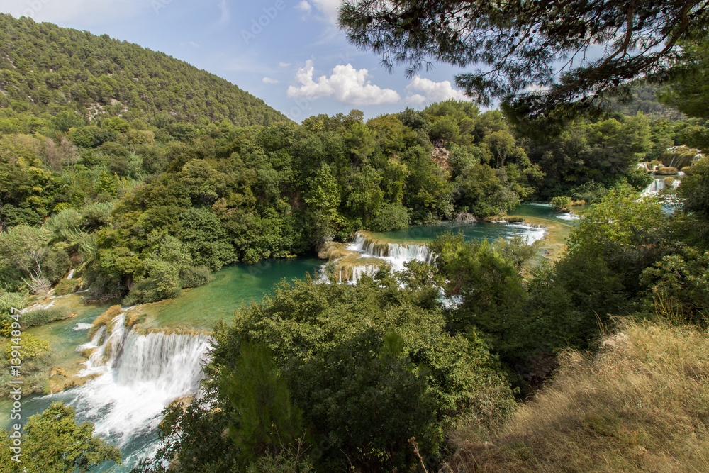 Scenic view of waterfalls, cascades and lush foliage at the Krka National Park in Croatia. Viewed slightly from above. Scenic view of waterfalls, cascades and lush foliage at the Krka National Park in Croatia. Viewed slightly from above.