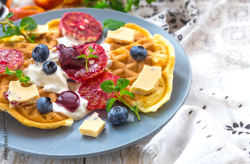 Belgium waffles with blueberry, blood orange, whipped cream. Breakfast