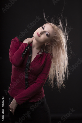 Woman with flying hair over a dark studio background