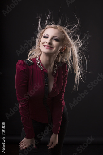 Happy young model with hair on the wind at studio