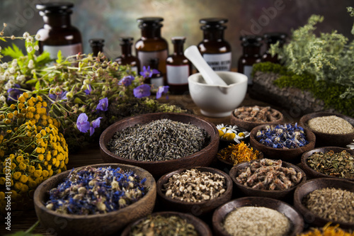 Herbs, berries and flowers with mortar, on wooden table background © Sebastian Duda