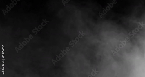 smoke slowly floating through space against black background