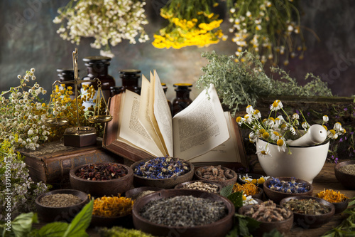 Herbal medicine and book on wooden table background
