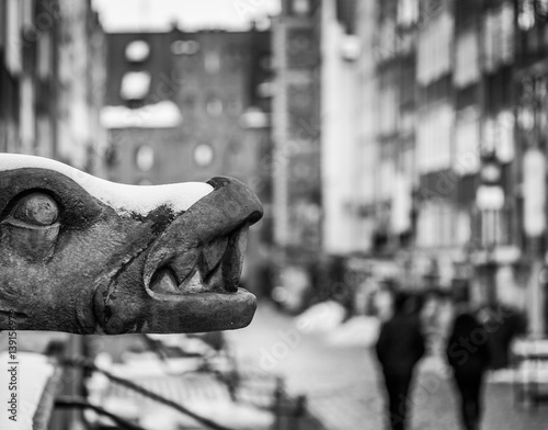 Gdansk gargoyle and people during walk at black and white