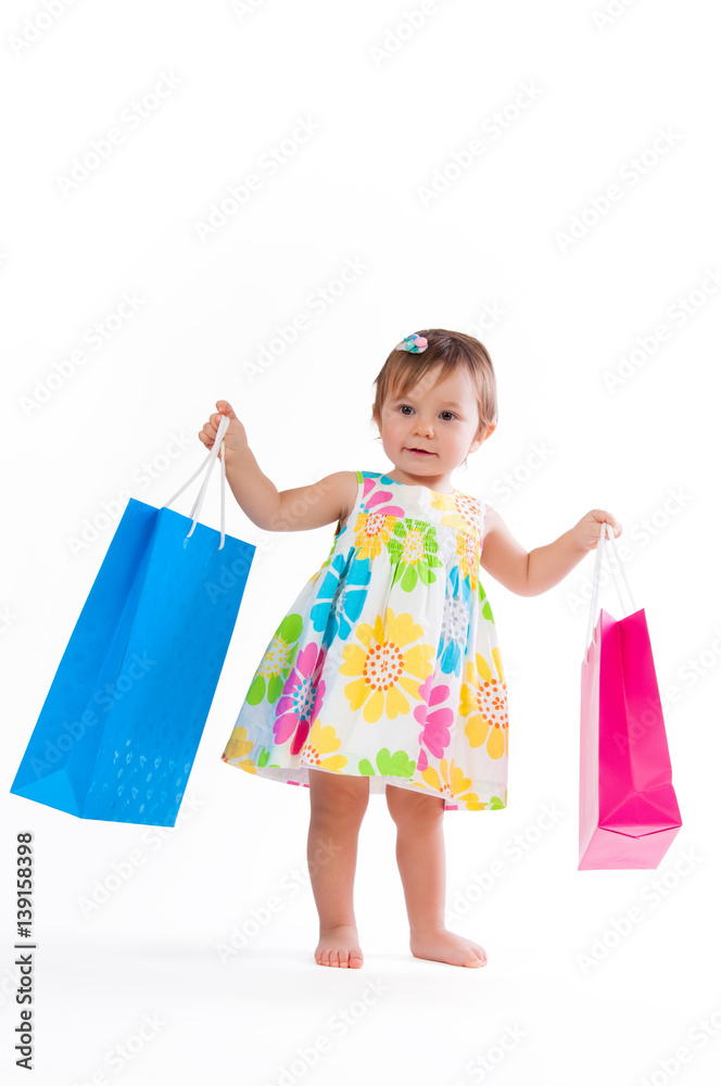 Little girl standing with colorful paper bags isolated on white background. Little girl standing with colorful paper bags isolated on white background.