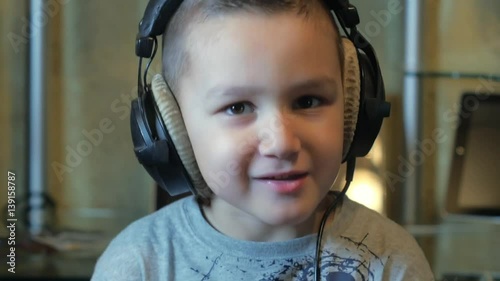 The boy listens to hard rock in headphones photo