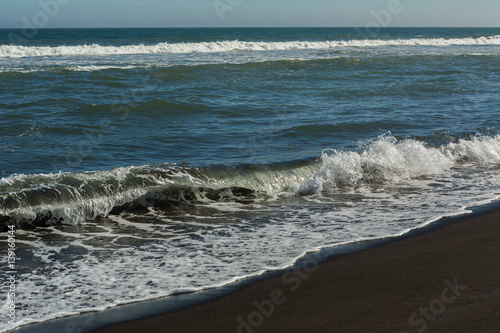 Khalaktyrsky beach with black sand. Pacific Ocean washes Kamchatka Peninsula. photo