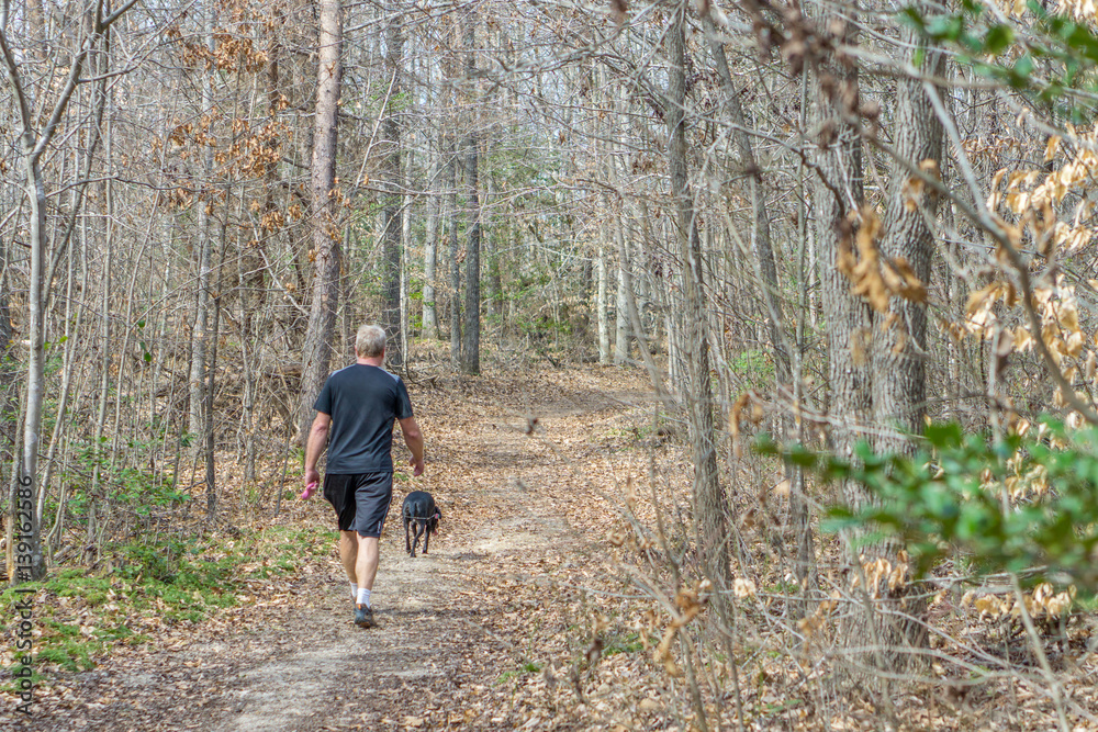 A Man Walking his Dog on a Trail A Man Walking his Dog on a Trail