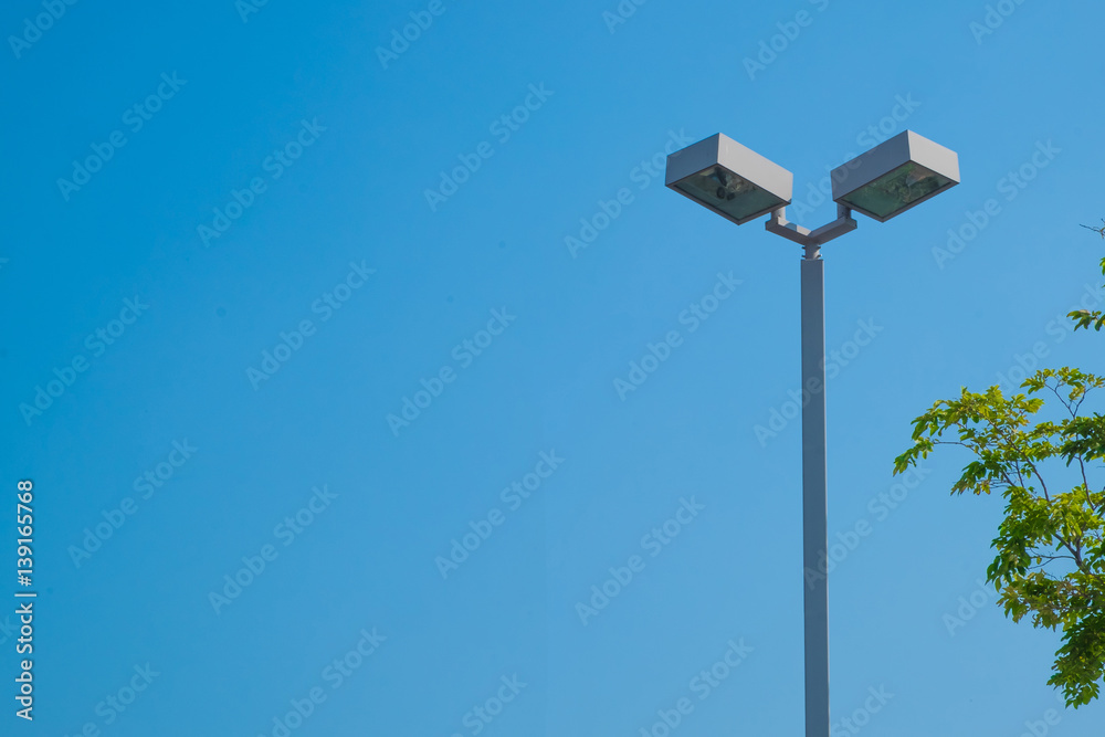 Lamp post electricity industry with blue sky background and tree. Spotlight tower. Lamp post electricity industry with blue sky background and tree. Spotlight tower.