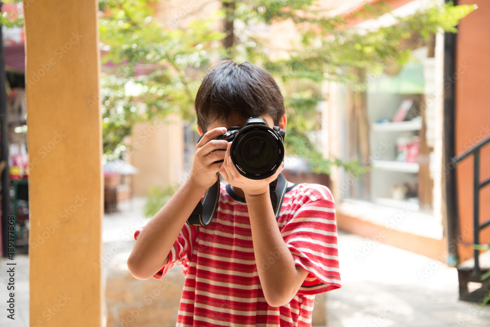 Little boy taking digital camera