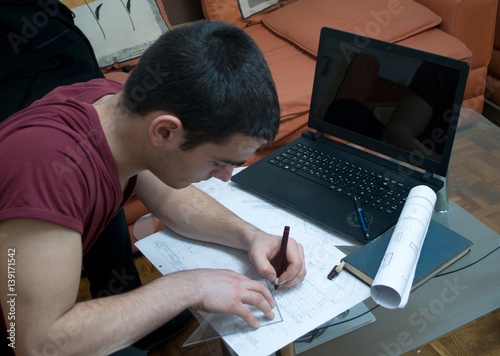 Photographing Danila Mazić in a tight red shirt and black pants while drawing construction plans, Novi Sad, Serbia