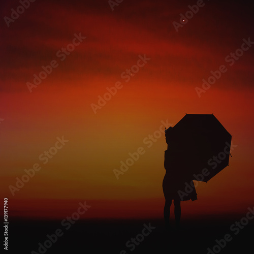 Umbrella little girl stand and sunset silhouette.