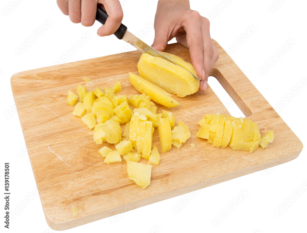 Chef cuts boiled potatoes on board on a white background Chef cuts boiled potatoes on board on a white background