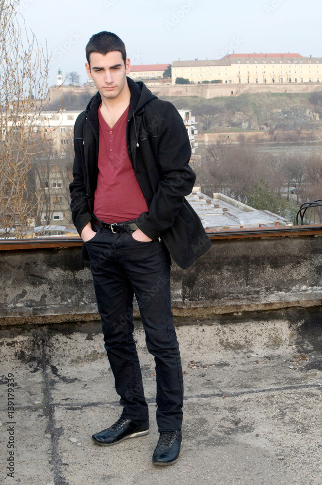 Photographing Danila Mazić in a tight red shirt covered with unbuttoned a black  coat and black pants a background Petrovaradin fortress and the Danube  River, Novi Sad, Serbia Stock Photo | Adobe