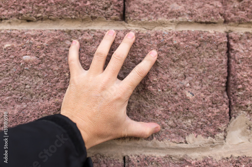 hand on the brick wall