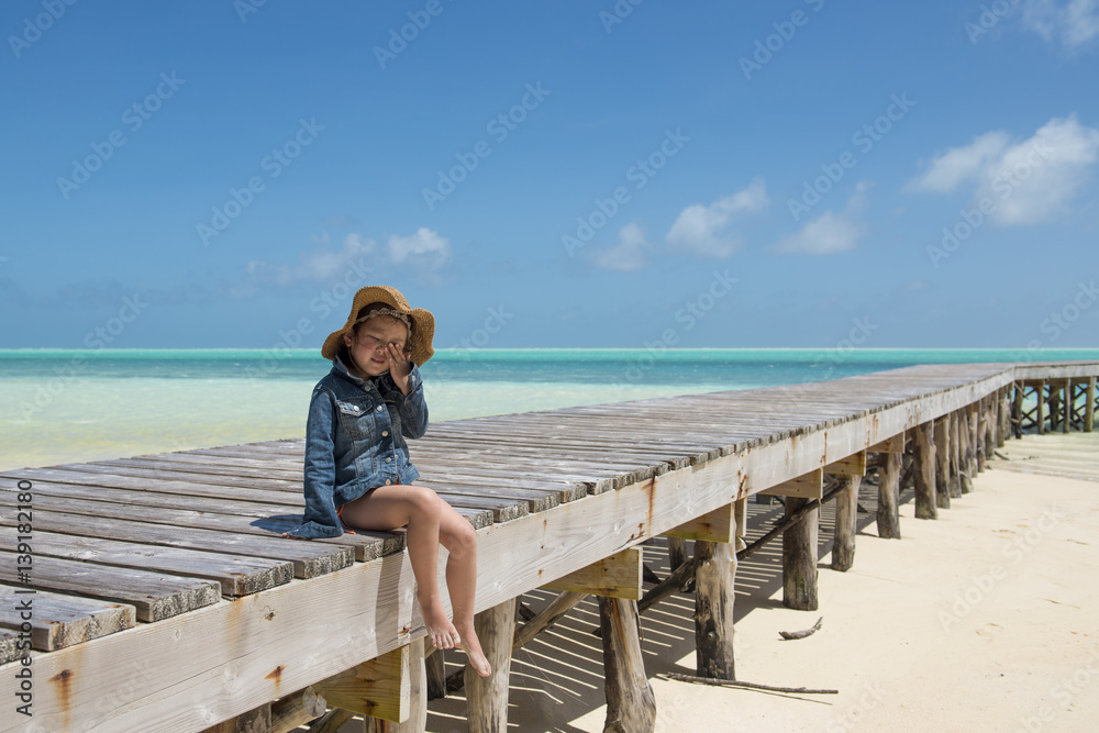 南の島の桟橋で座る女の子