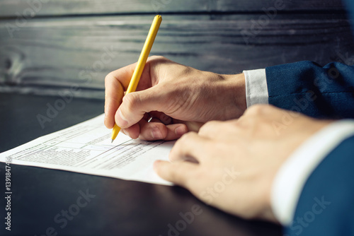 Foto Man lawyer or official signs documents with a pen