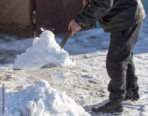 Worker cleans snow shovel