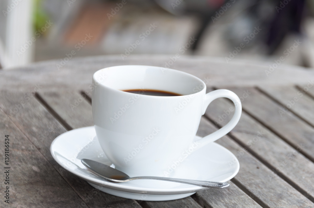 white cup of coffee on wooden table, soft focus