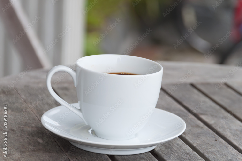 white cup of coffee on wooden table, soft focus