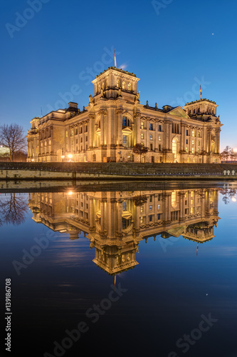 Canvas Print The famous Reichstag in Berlin at dawn reflects in the river Spree