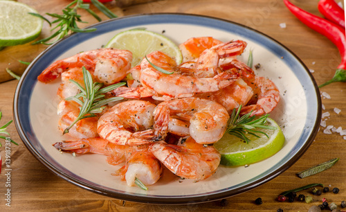 Grilled shrimps on a plate with seasonings.