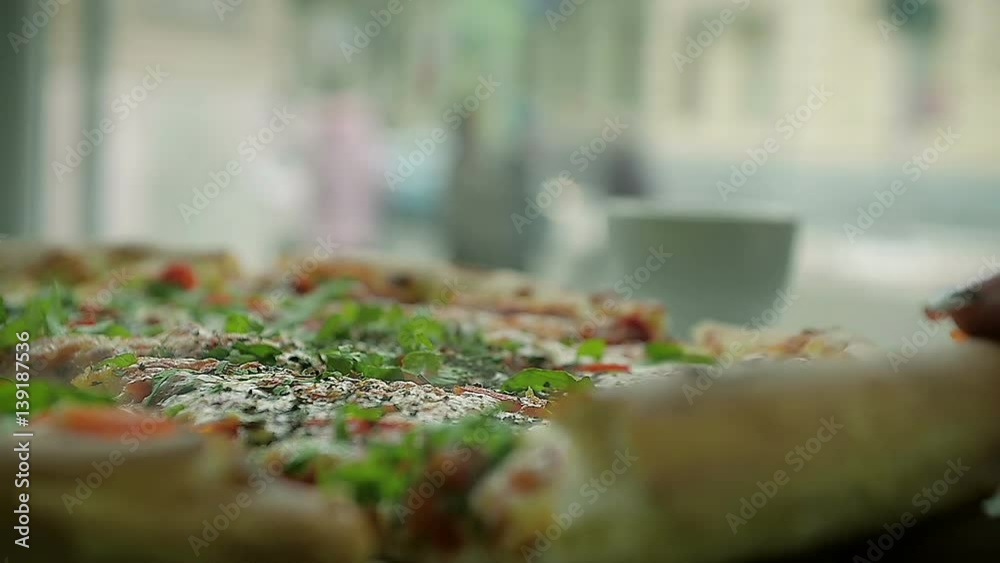 Close-Up of Female Hand Takes a Piece of Hot Pizza in a Restaurant Close-Up of Female Hand Takes a Piece of Hot Pizza in a Restaurant
