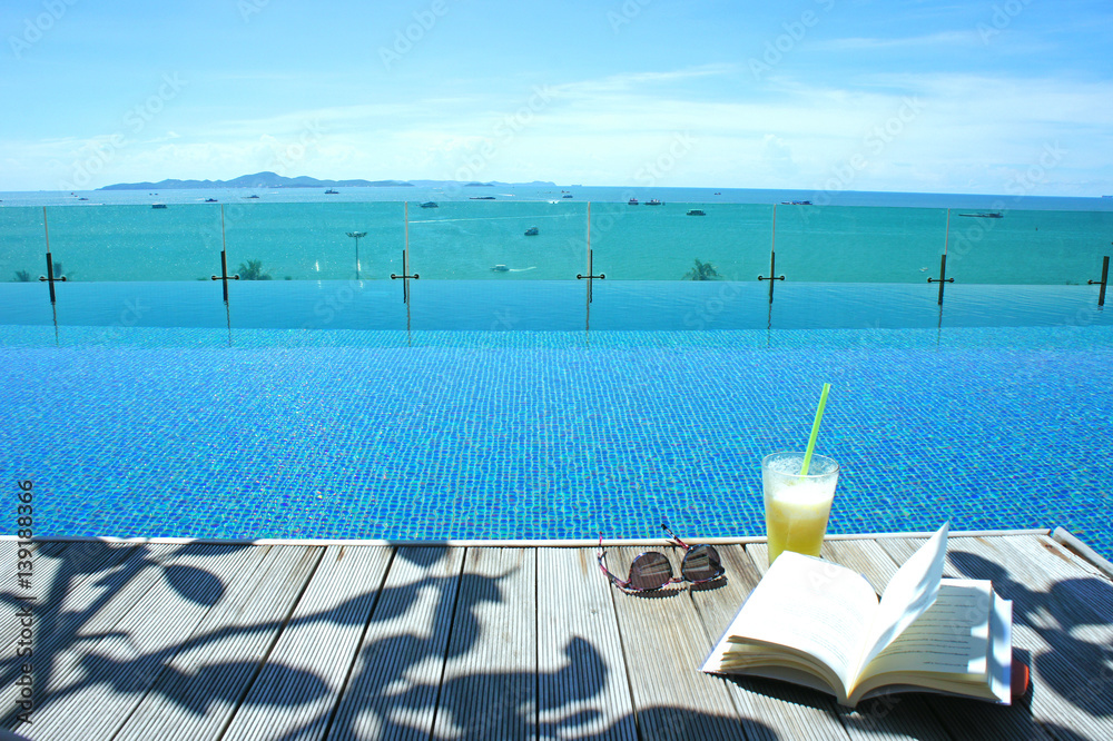 Obraz premium relax cocktail book sun glass at swimming pool island view