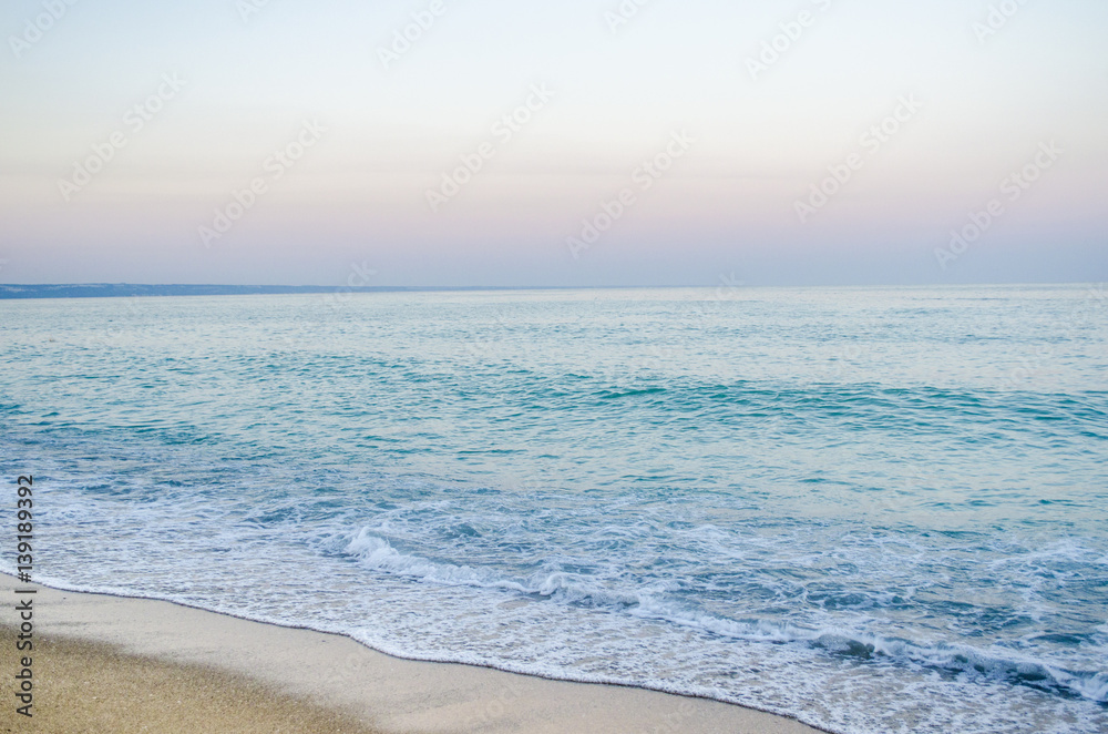 summer landscape, the sand on the beach, blue sea with waves.