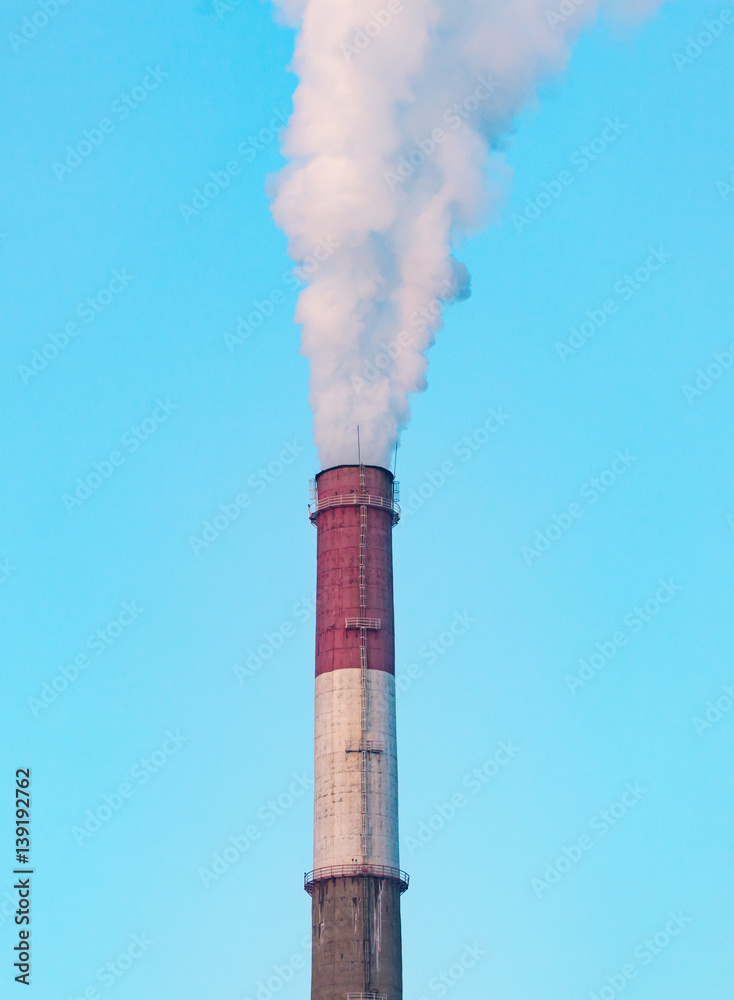 white industrial smoke from the chimney on a blue sky