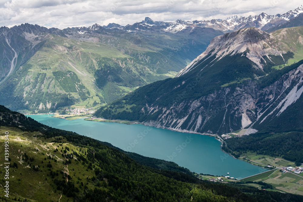 Panoramic view from top of the mountain on lake Muta (Haidersee), near the village St. Valentino, Alps on background, Tyrol, Bolzano, Italy