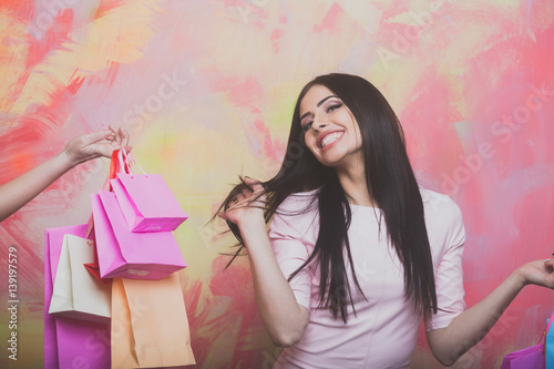 pretty sexy smiling woman with shopping bags on colorful background