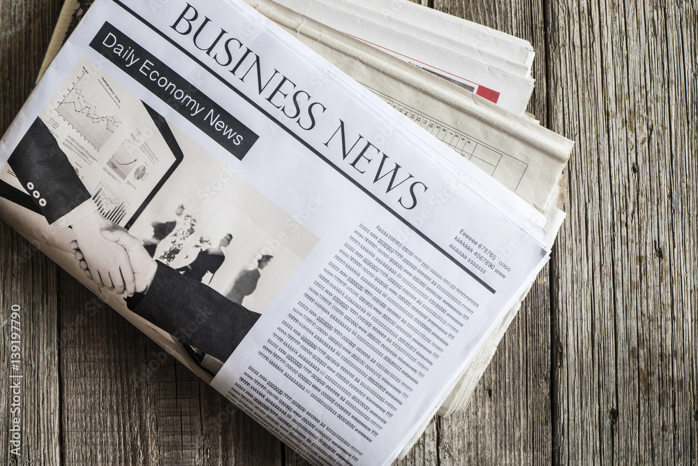 Naklejka premium Reading newspaper on wooden table