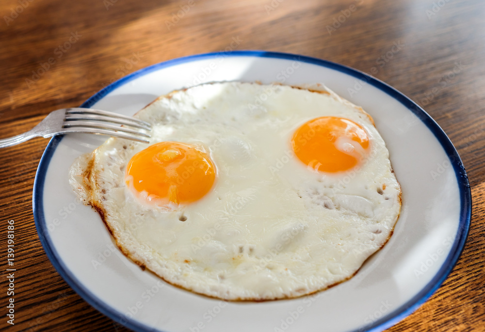 Two fried eggs like a smiley face on the tray with the light blue platter Two fried eggs like a smiley face on the tray with the light blue platter