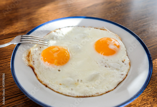 Two fried eggs like a smiley face on the tray with the light blue platter