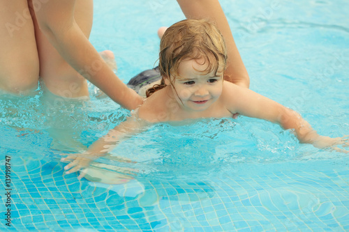 Cute baby boy learns to swim with mothers help © Volodymyr