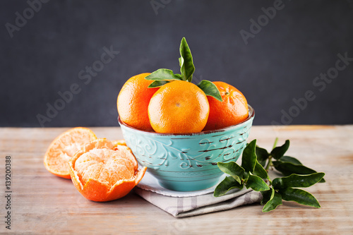Organic Mandarin Fruit in Blue Bowl on Rustic Wooden Background