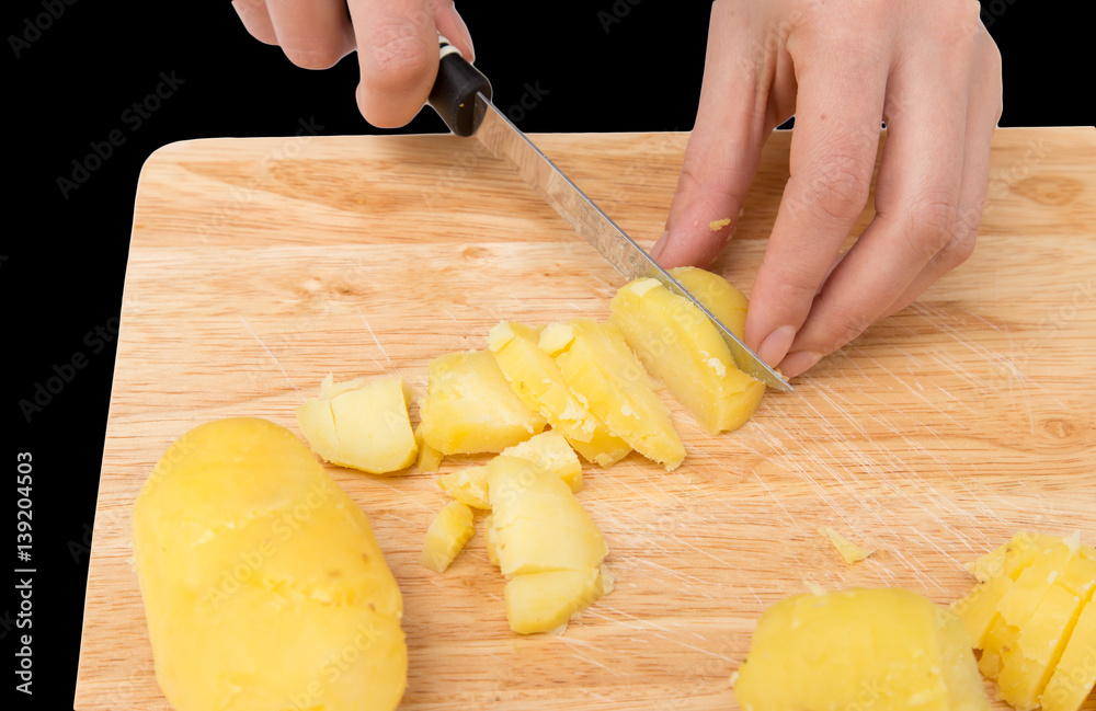 boiled potatoes on board on a black background boiled potatoes on board on a black background