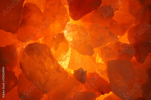 Background of salt crystals with orange lighting in the lamp. Close-up photo