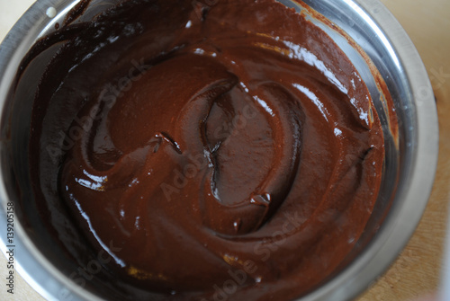 The texture of melted chocolate. In a steel bowl. Close-up