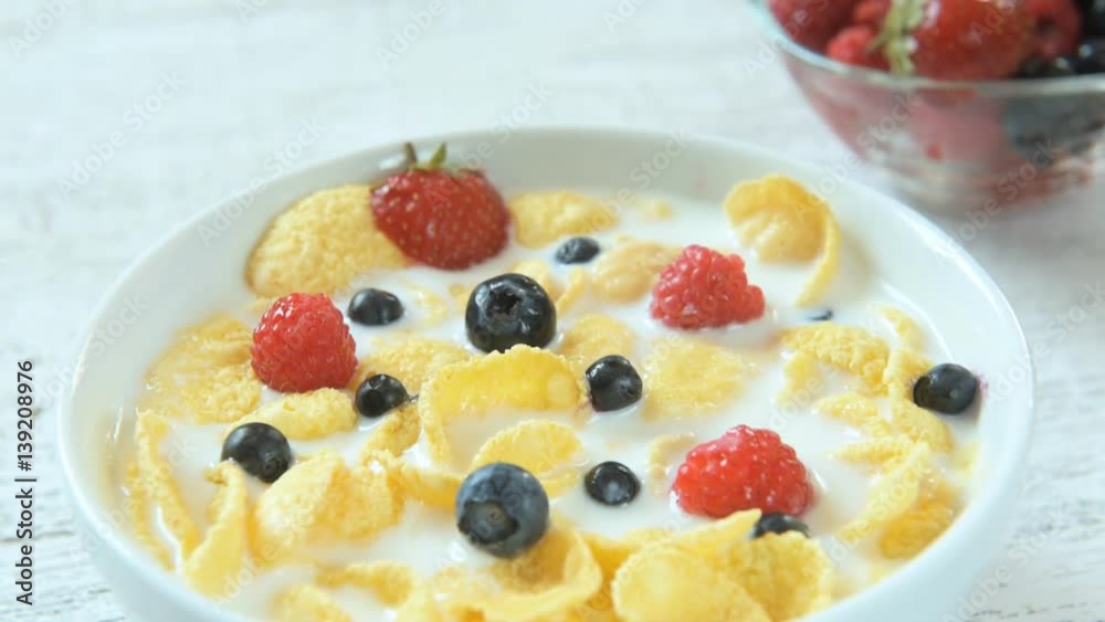 Cereal flakes with fresh berries, honey and milk for breakfast, close-up Cereal flakes with fresh berries, honey and milk for breakfast, close-up