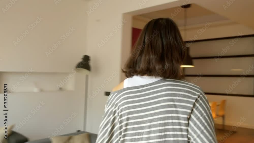Woman looking through the window and walking in the flat, steadycam shot
Woman looking through the window and walking in the flat, steadycam shot
