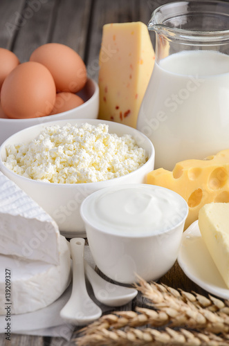 Fresh dairy products. Milk, cheese, brie, Camembert, butter, yogurt, cottage cheese and eggs on wooden table.