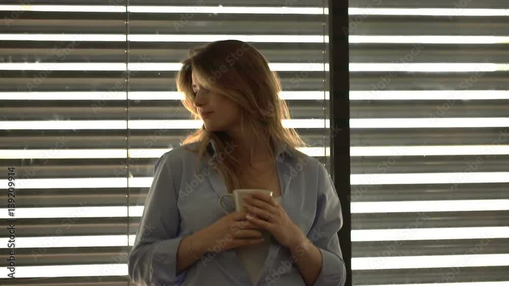 Thoughtful woman standing next to the window and drinking coffee, steadycam shot
Thoughtful woman standing next to the window and drinking coffee, steadycam shot