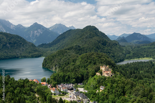 View from top to world-famous Hohenschwangau Castle  Schloss  and Alpsee lake from the cliff  Alps and clouds on background  Fussen  Bavaria   Germany