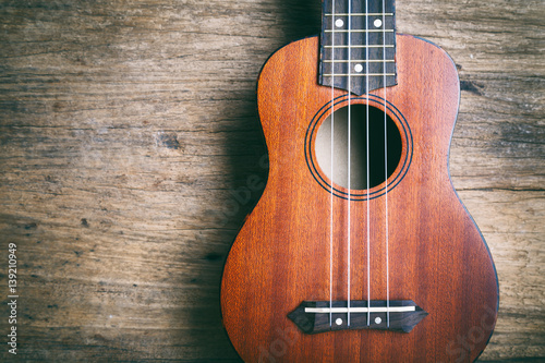 Ukulele with a rustic wood background.