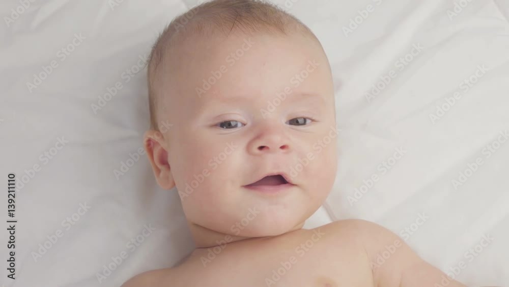 Cute four-month-old baby in blanket. Close up.
Cute four-month-old baby in blanket. Close up.