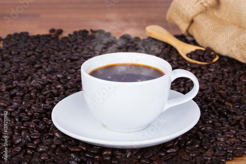 Coffee cup and beans on wooden background